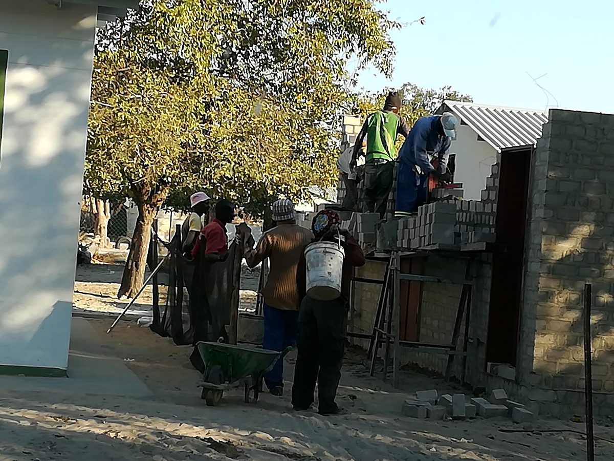 Nofrica team members carrying materials on site