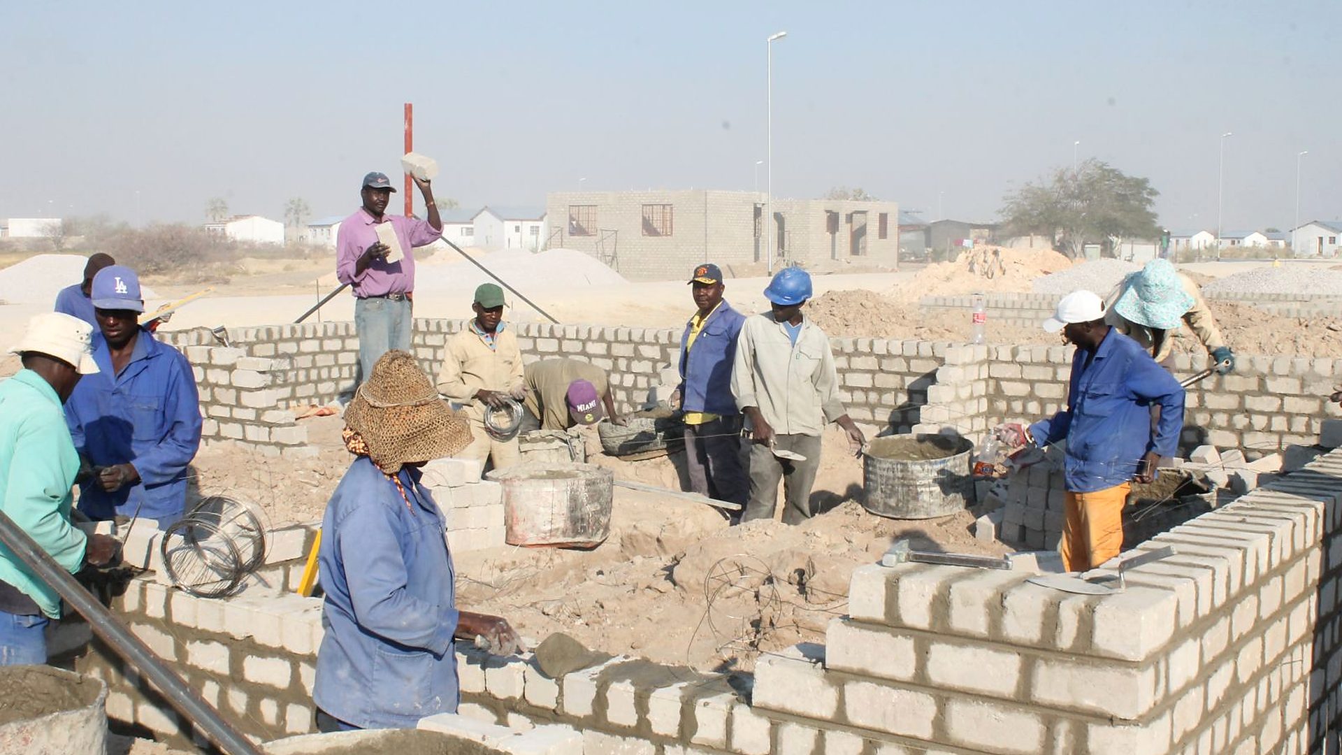 Bricklayers raising walls on a Nofrica site